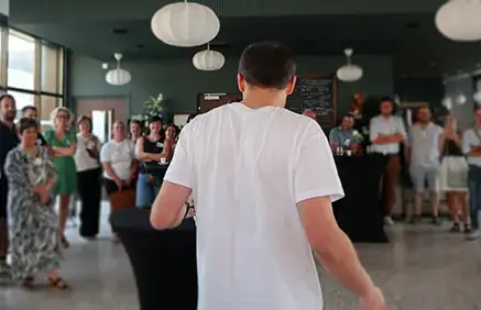 Intervenant debout s’adressant à un groupe de personnes lors d’une rencontre conviviale